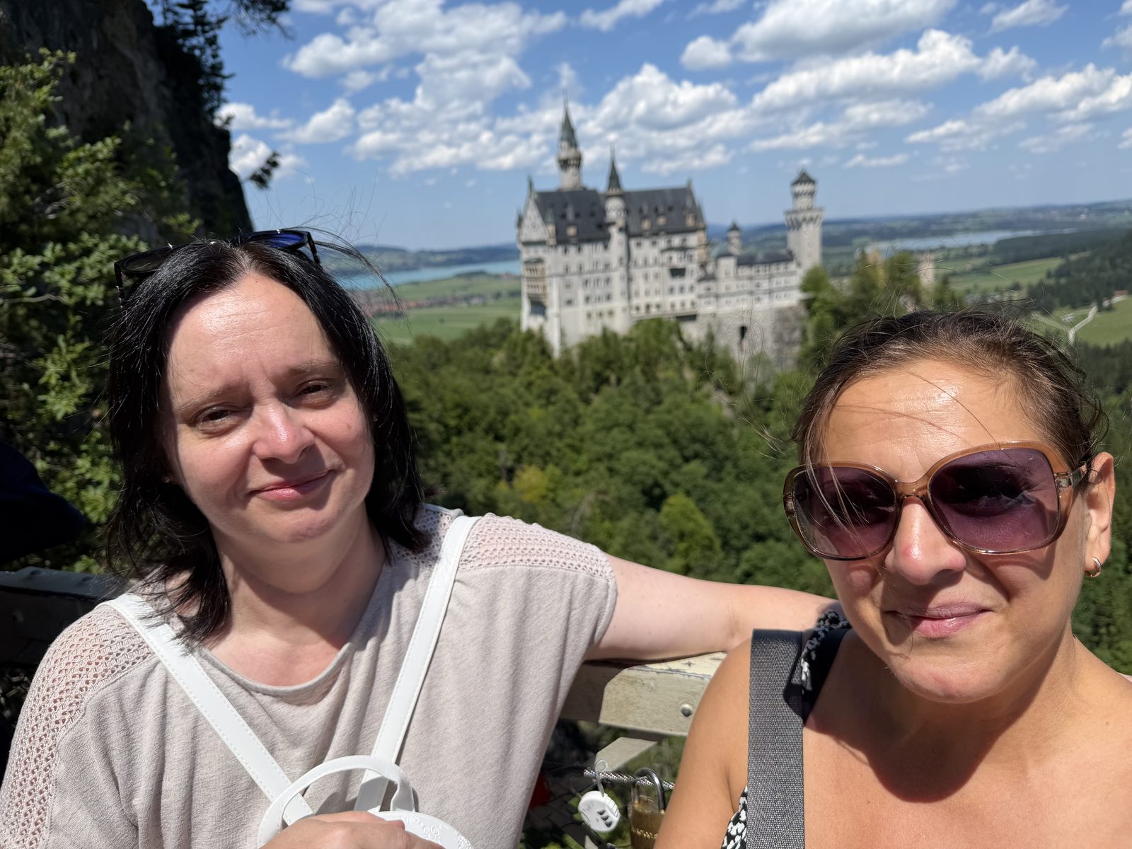 Két nő portréja, mögöttük a Neuschwanstein panorámája
